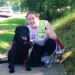 Image of Karen from Rock Creek Conservancy and her dog Milo with the poop loop sign.