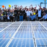 people celebrating by solar panels