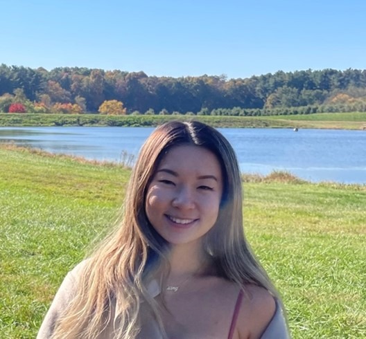 Headshot of XiangXiang Fang, climate fellow, in an outdoor location. She is smiling with a lake behind her.
