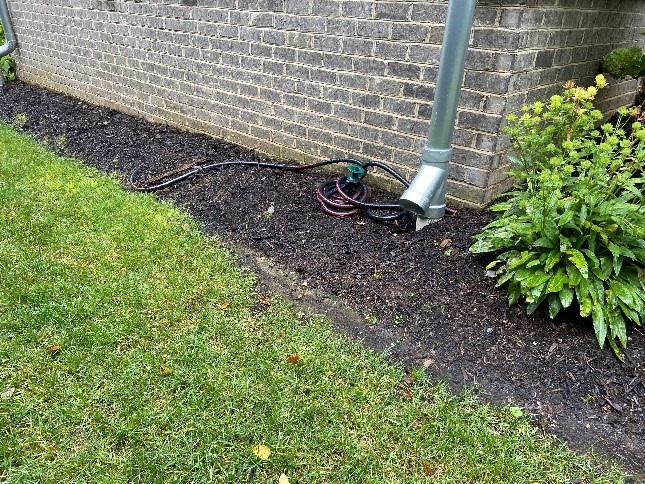 Downspout into mulched garden bed.