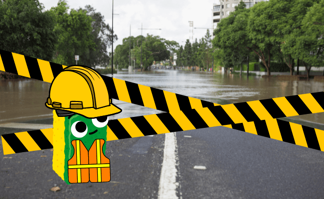 A cartoon sponge wearing a hard hat and neon vest stands in front of a flooded road that is blocked off by caution tape. 