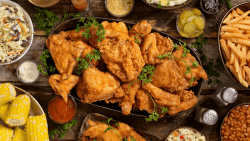 image of a table with potluck food including chicken and other foods on a table